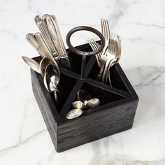 there are silverware in the holder on the marble table