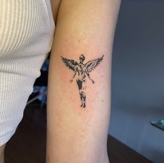 a woman's arm with a tattoo of an angel on the back of it