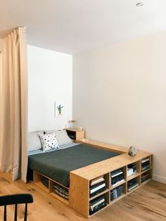 a bed sitting in the middle of a bedroom next to a wooden table and chair