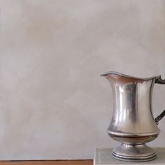 a silver pitcher sitting on top of a table