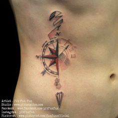 a woman's stomach with a compass tattoo on the side and an arrow in the middle