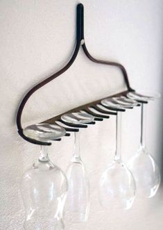 three wine glasses are hanging from a rack