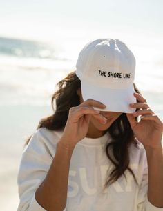 The logo baseball hat is a cotton hat that features an adjustable back strap. The embroidered THE SHORE LINE logo in contrast stitching sits at the center front. Size - one size fits most Beach Merch Photoshoot, White Cotton Baseball Cap For Beach, White Cotton Beach Baseball Cap, Beach Baseball Cap With Curved Bill For Baseball Season, Curved Bill Fitted Hat With Embroidered Logo, Curved Bill Baseball Cap For Beach And Baseball Season, White Cotton Baseball Cap With Embroidered Logo, White Cotton Baseball Cap Dad Hat, White Hats With Embroidered Logo For Everyday