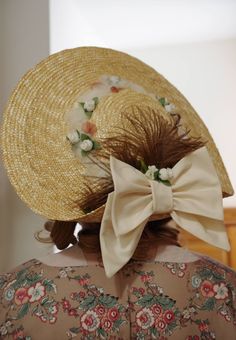 Regency style low crown straw hat with turned up brim in the back, accented with ivory double bow, feather, tulle and small flowers. Satin ribbons are at the sides which can tie under the chin. Spring Curved Brim Boater Hat With Bow, Spring Boater Hat With Bow And Curved Brim, Spring Boater Hat With Curved Brim And Bow, Short Brim Boater Hat With Bow For Garden Party, Classic Spring Hat With Bow, Brimmed Boater Hat With Bow For Kentucky Derby, Wide Brim Boater Hat With Bow For Kentucky Derby, Elegant Spring Straw Hat With Bow, Boater Hat With Bow For Kentucky Derby