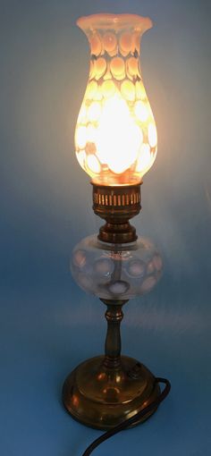 a lamp that is sitting on top of a blue surface with a cord attached to it