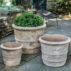 three cement planters sitting next to each other on a patio