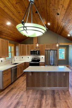 an empty kitchen with wood paneling and stainless steel appliances