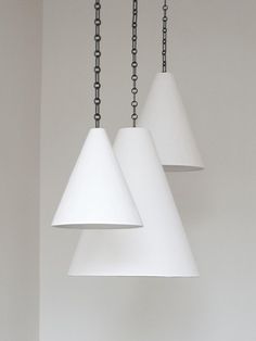 three white lamps hanging from chains in a room