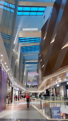 the inside of a shopping mall with people walking around