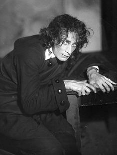 black and white photograph of a man leaning on a table with his hand resting on the edge