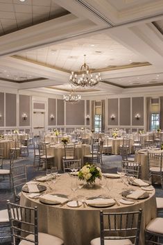 a banquet room with tables, chairs and chandeliers set up for an event