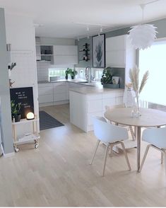 an open kitchen and dining room with white furniture