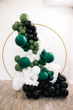 the balloon arch is made up of black, white and green balloons