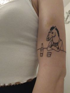 a woman with a horse tattoo on her arm holding a drink and looking at the camera