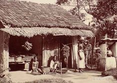 an old black and white photo of people in front of a hut