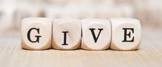 the word give spelled with dices on a table