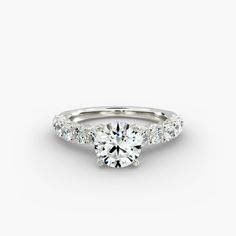 a white gold engagement ring with round brilliant cut diamonds on the band and side stones