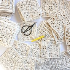 crocheted coasters and scissors laid out on a white tablecloth with yellow marker