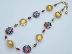 "Millefiori Murano Venetian Glass Bead Necklace; adjustable length, 19 inches to 21 inches with gold filled link chain, and gold filled, large, lobster style spring clasp. I designed this multicolored, mosaic, fine millefiori necklace with 24 karat gold foil beads, to make an outstanding combination. Millefiori translates from Italian to English to mean \"thousand flowers\". Fine Millefiori: Each handmade bead is the finest Millefiori made in Murano. The Murano artisan smooths and polishes each Adjustable Gold Murano Glass Necklaces, Adjustable Murano Glass Necklace, Adjustable Round Murano Glass Necklace, Italian To English, Murano Glass Necklaces, 24 Karat Gold, Bugle Beads, Venetian Glass, Handmade Beads