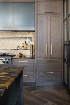 a kitchen with wooden cabinets and marble counter tops