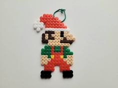 an ornament made out of perler beads with a santa clause on it