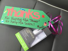 a thank card with a pink ribbon tied around it on the back of a car seat