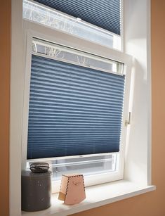 a window with blue blinds and a small item on the ledge in front of it