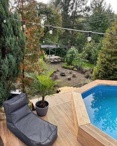 an above ground swimming pool in the middle of a backyard with a deck and lounge chair