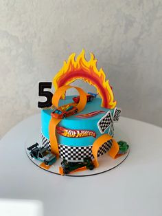 a birthday cake that is shaped like a race car with the number five on it