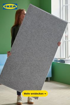 a woman is holding up a large piece of felt