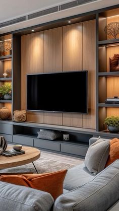 a living room filled with furniture and a flat screen tv mounted on a wall above it