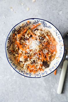 an overhead view of a bowl of food with carrots, nuts and parmesan cheese