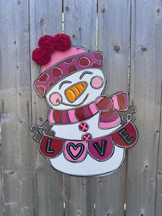 a wooden fence with a painted snowman on it