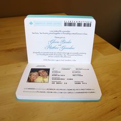 an open passport with a photo on the front and inside is sitting on a wooden table