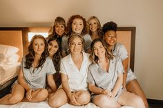 a group of women sitting on top of a bed