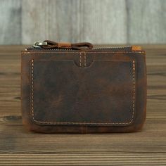 a brown leather wallet sitting on top of a wooden table