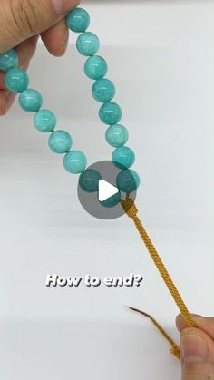 a person holding a beaded string with the words how to end? on it