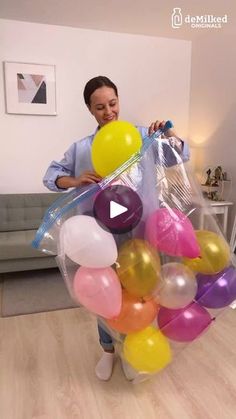 a woman is holding balloons in her hands