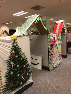 two cubicles decorated like christmas trees with decorations on them and one has an umbrella over the top