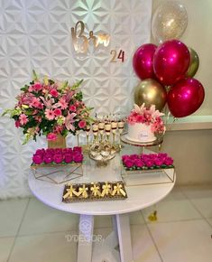 the dessert table is decorated with pink flowers and gold accents, including cupcakes