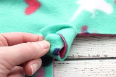 someone is stitching something on the fabric with their thumbnails to make it easier for them to sew