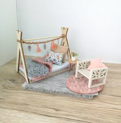 a dollhouse bedroom with a bed, desk and chair on the floor next to it