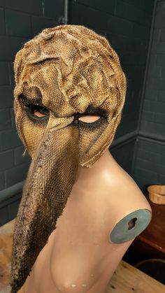 a mannequin wearing a mask with an animal's head sticking out of it