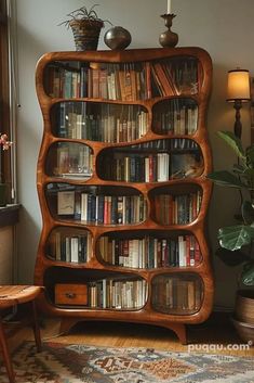 a bookshelf filled with lots of books on top of a wooden floor next to a window