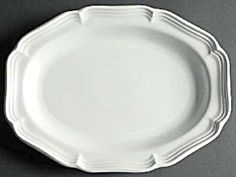 a white plate sitting on top of a gray tablecloth covered floor next to a knife and fork