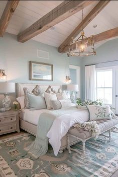 a bedroom with a large bed and lots of pillows on the headboard, along with a chandelier hanging from the ceiling