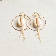 "Beautiful sliced cowrie shells hang within gold filled hammered hoops and have delicate gold chains dangling from them. Hoops measure approximately 1 1/2\". Each cowrie shell is unique so please allow for variations." Cowrie Shell Earrings, Beachy Earrings, Shell Hoop Earrings, Cowrie Shells, Cowrie Shell, Shell Earrings, Honolulu, Earrings Gold, Gold Chain