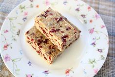 two pieces of granola bars on a white plate with floral designs and pink flowers