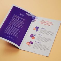 an open brochure on a yellow table with purple and orange designs in it