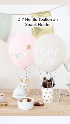 a table topped with lots of balloons and desserts